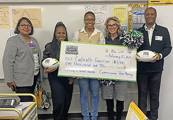  group holding a check made out to Hancock ES teacher
